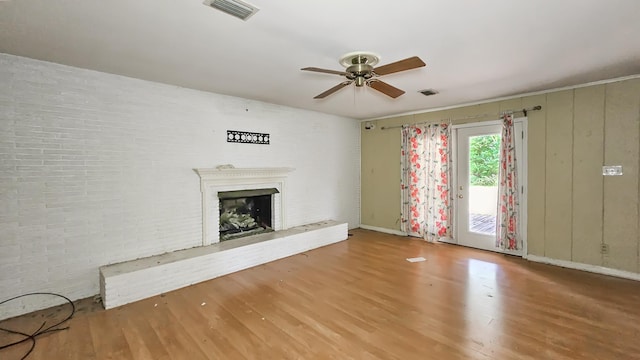  - unfurnished living room featuring wood finished floors, ceiling fan, and a fireplace