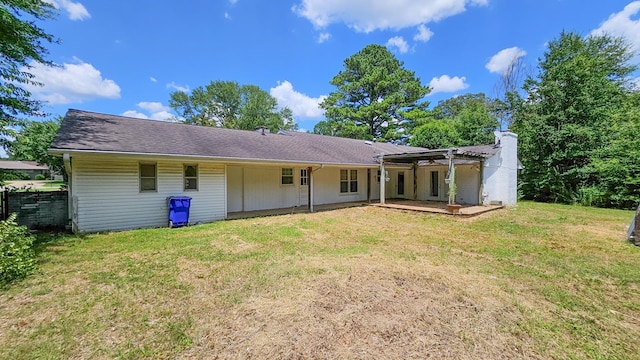  - rear view of house featuring a yard, a patio, and a chimney