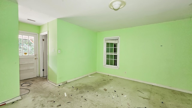  - empty room with baseboards and concrete flooring