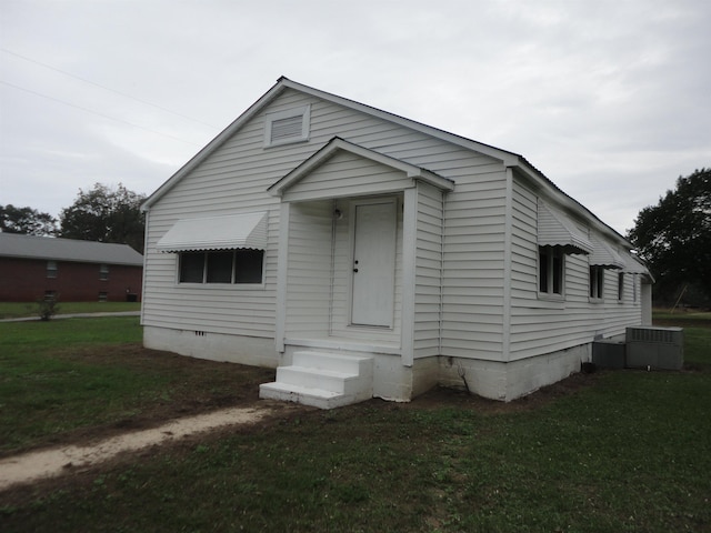 bungalow with central AC unit and a front lawn