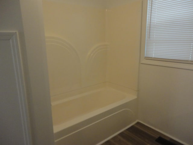 bathroom with hardwood / wood-style floors and a bath