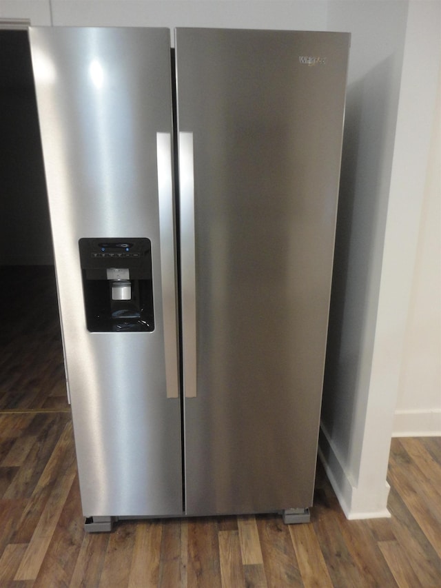 room details featuring stainless steel fridge with ice dispenser and dark hardwood / wood-style floors