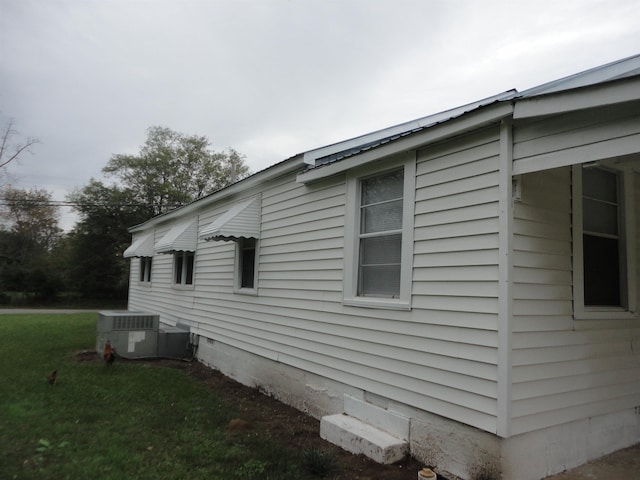 view of property exterior with a yard and cooling unit