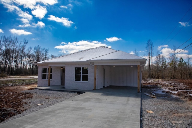 view of front of house with a carport, brick siding, and driveway