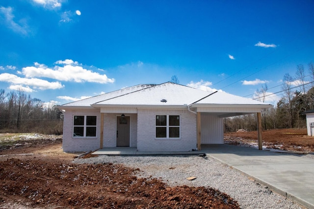 view of front of house featuring a carport, brick siding, and driveway