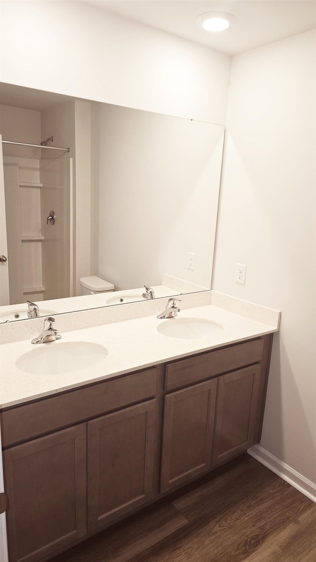 bathroom featuring hardwood / wood-style floors, vanity, toilet, and walk in shower