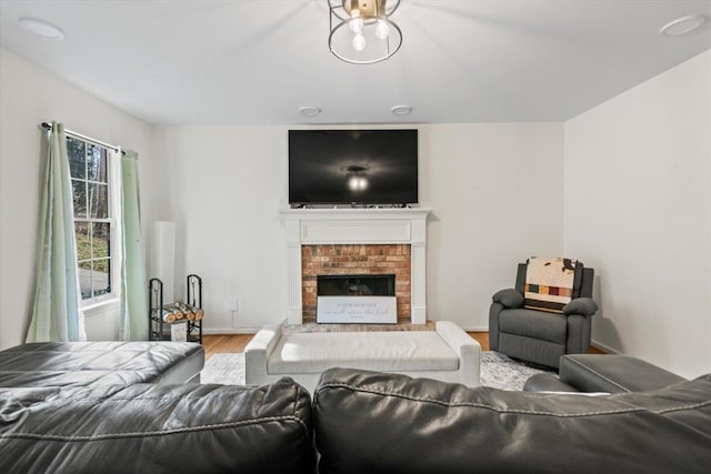 living area featuring a fireplace, wood finished floors, and baseboards