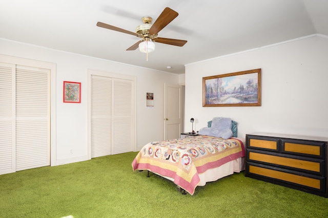  - carpeted bedroom featuring two closets, a ceiling fan, and crown molding
