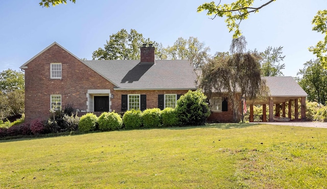 - view of front of house featuring brick siding, driveway, a chimney, and a front lawn