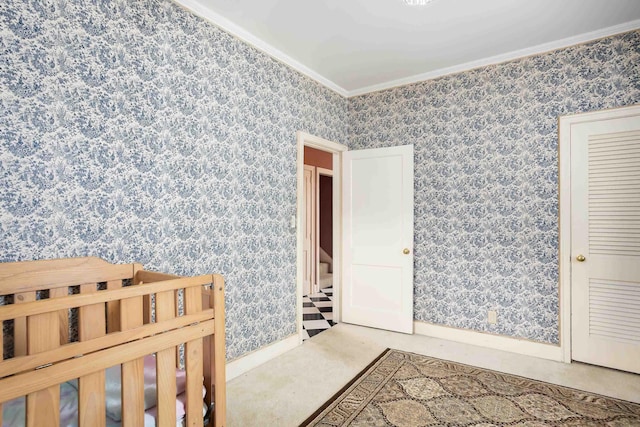  - unfurnished bedroom with baseboards, ornamental molding, carpet flooring, and wallpapered walls