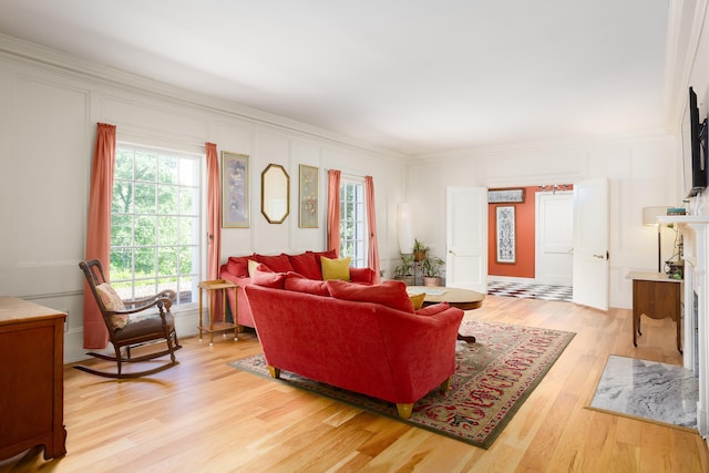  - living room featuring crown molding, a decorative wall, and light wood finished floors