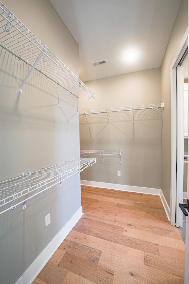 spacious closet with hardwood / wood-style floors