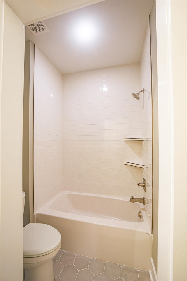 bathroom featuring shower / tub combination, tile patterned flooring, and toilet