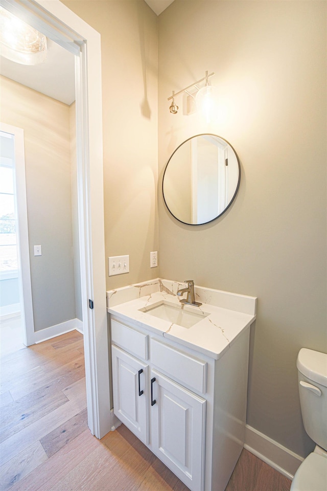 bathroom featuring toilet, vanity, and hardwood / wood-style flooring