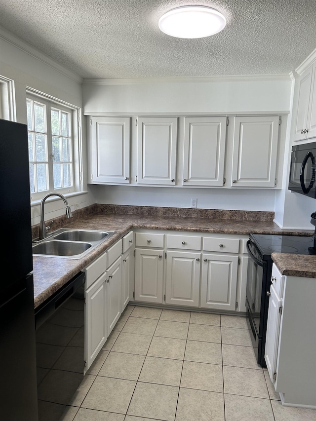 kitchen featuring dark countertops, white cabinetry, a sink, and black appliances