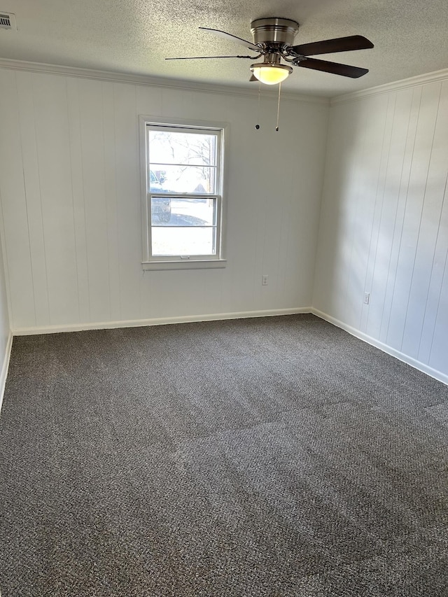 unfurnished room featuring a textured ceiling, dark colored carpet, visible vents, and crown molding