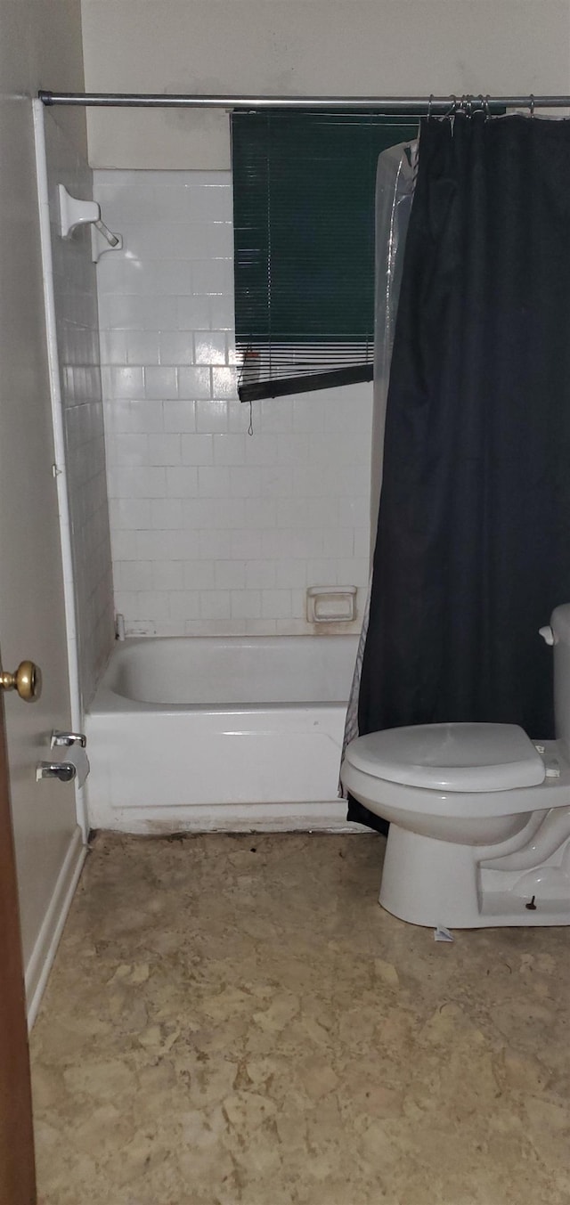 bathroom featuring shower / tub combo and toilet