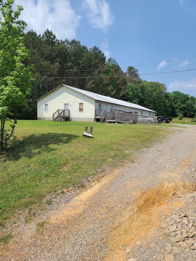 exterior space with a deck, driveway, and a front lawn