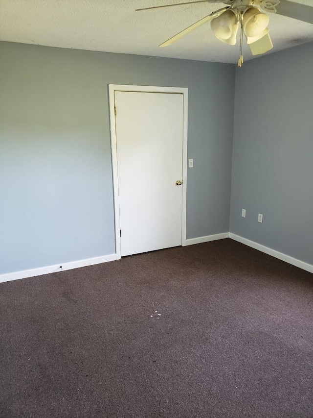 carpeted spare room with a ceiling fan, a textured ceiling, and baseboards