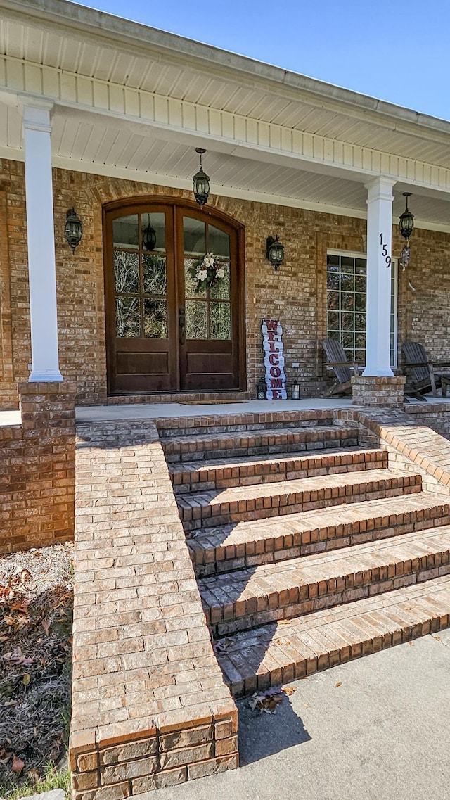 doorway to property with a porch and french doors