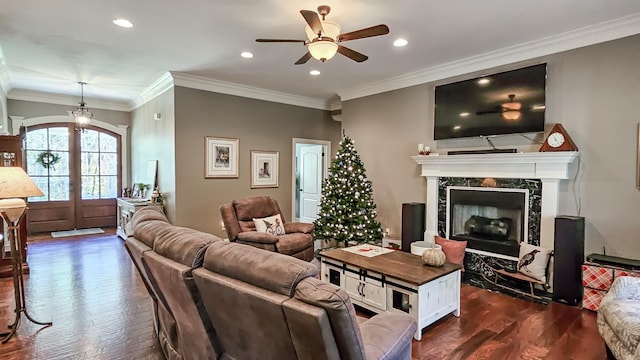 living room with a premium fireplace, dark hardwood / wood-style flooring, ceiling fan, and ornamental molding