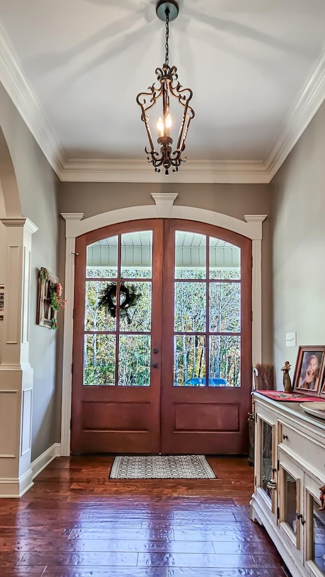 doorway to outside with a chandelier, french doors, dark hardwood / wood-style floors, and ornamental molding