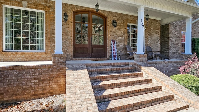 view of exterior entry with french doors and covered porch