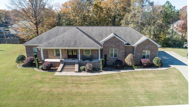 ranch-style home with covered porch and a front lawn