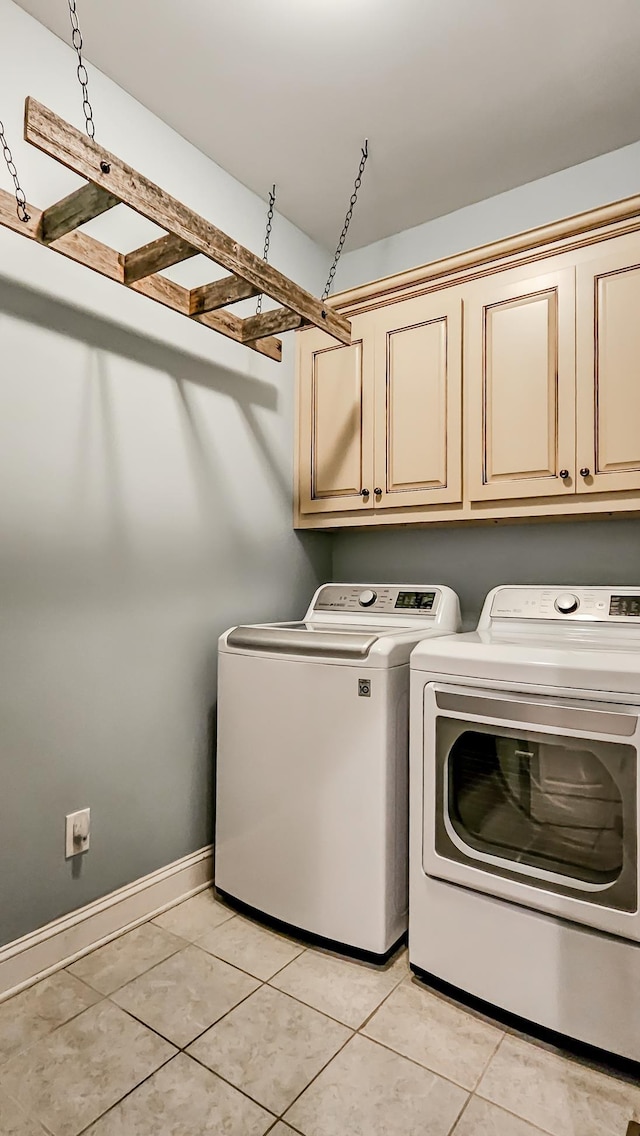 laundry area featuring cabinets, independent washer and dryer, and light tile patterned floors