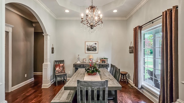 dining room featuring ornate columns, ornamental molding, dark hardwood / wood-style floors, and a notable chandelier