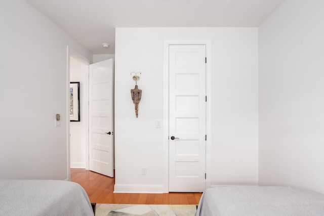 bedroom with light wood-type flooring and baseboards