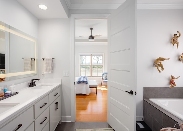 bathroom with ornamental molding, wood finished floors, connected bathroom, and a sink