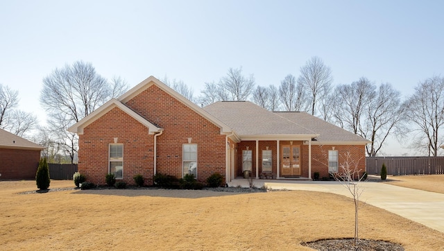 ranch-style home featuring concrete driveway, fence, and brick siding