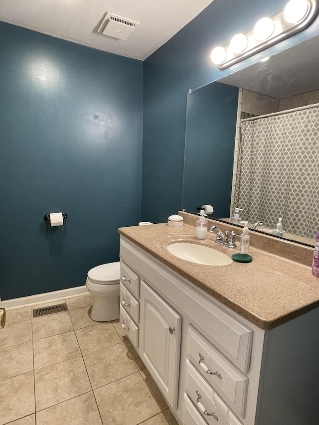 bathroom featuring tile patterned flooring, vanity, and toilet