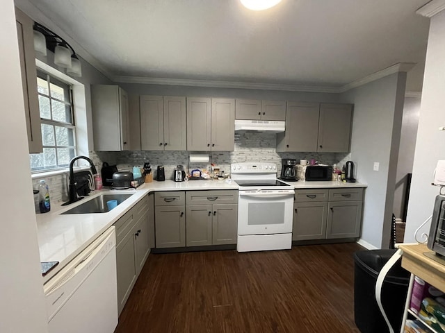 kitchen with sink, gray cabinetry, ornamental molding, dark wood-type flooring, and white appliances