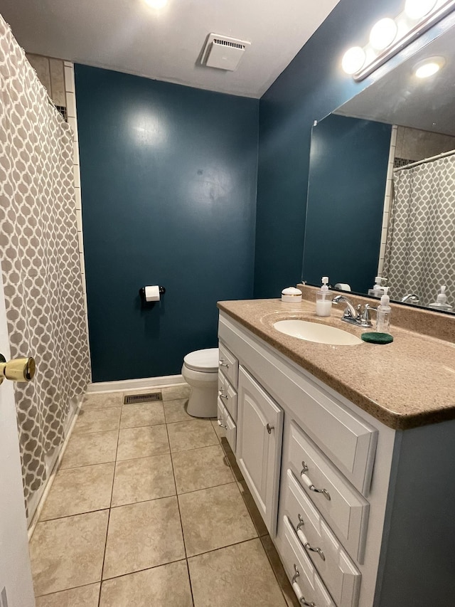 bathroom featuring tile patterned flooring, vanity, and toilet