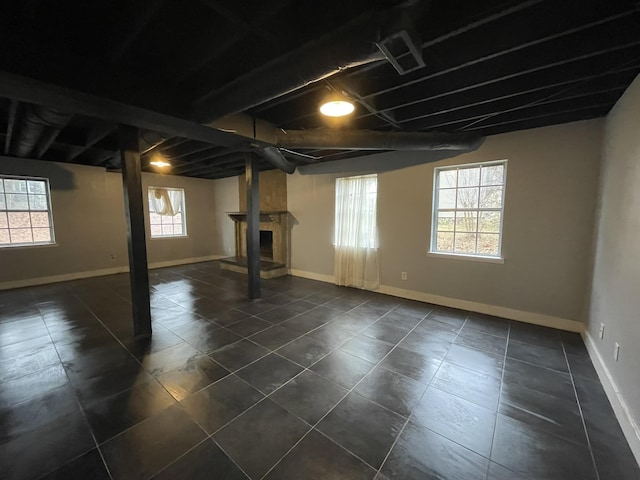 basement featuring dark tile patterned floors and a fireplace