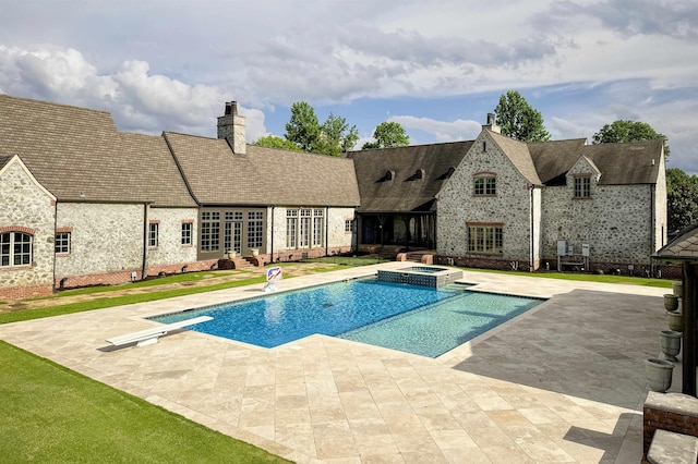  - view of swimming pool with a patio, a pool with connected hot tub, and a diving board