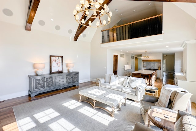  - living area with high vaulted ceiling, a chandelier, wood finished floors, baseboards, and beamed ceiling
