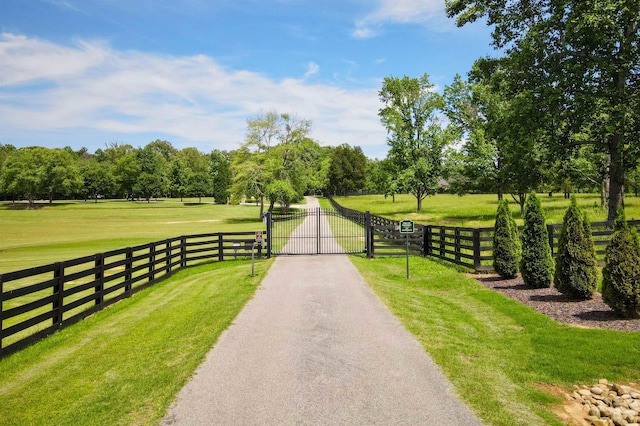  - view of street featuring a gate and view of wooded area