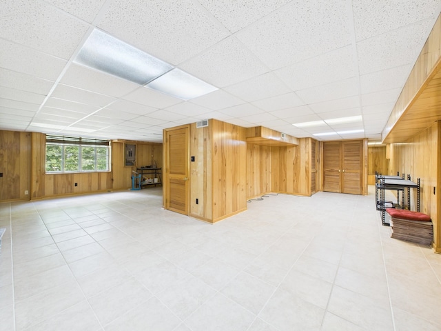  - below grade area with wood walls, a paneled ceiling, and electric panel