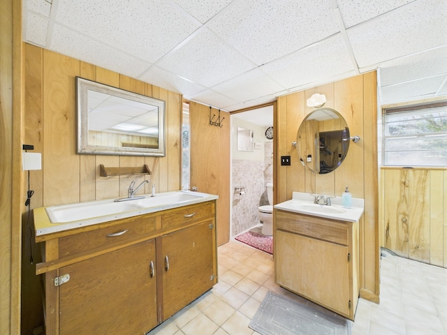  - bathroom featuring vanity, a paneled ceiling, wooden walls, and tile patterned floors