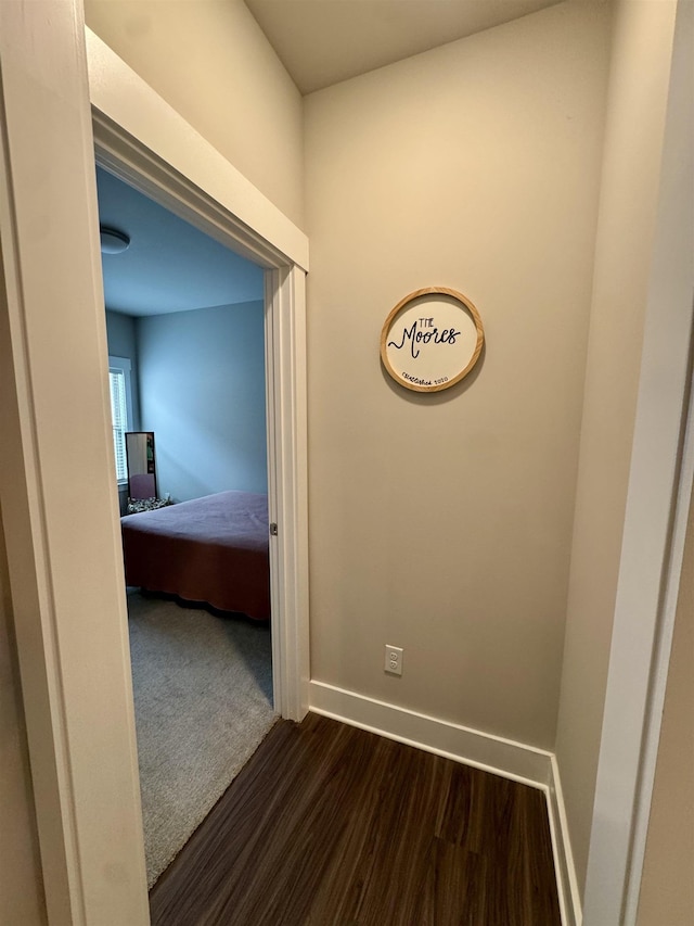 hall with baseboards and dark wood-style flooring