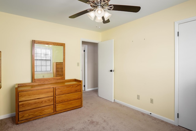 bedroom with light carpet, baseboards, and a ceiling fan