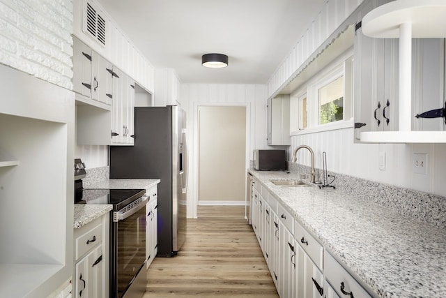 kitchen featuring sink, light stone counters, white cabinetry, and electric stove