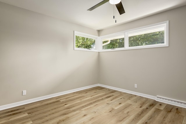 spare room featuring light wood-type flooring, baseboard heating, and ceiling fan