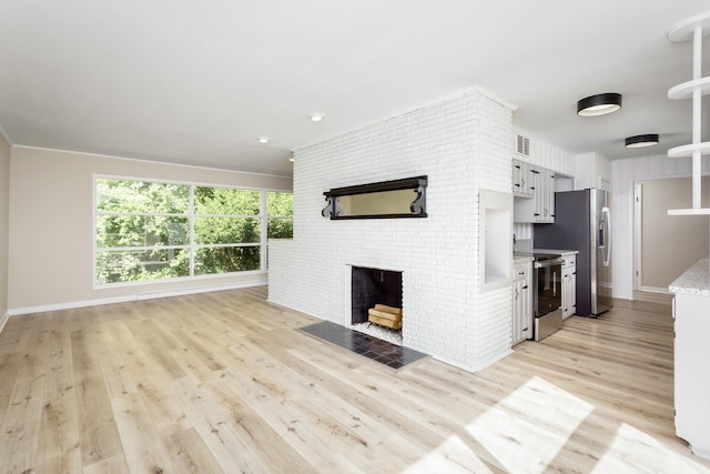 kitchen with a fireplace, stainless steel appliances, light hardwood / wood-style flooring, and white cabinets