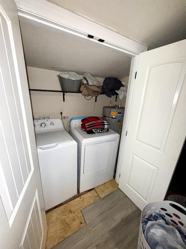  - washroom with washing machine and dryer, light wood-type flooring, and electric water heater