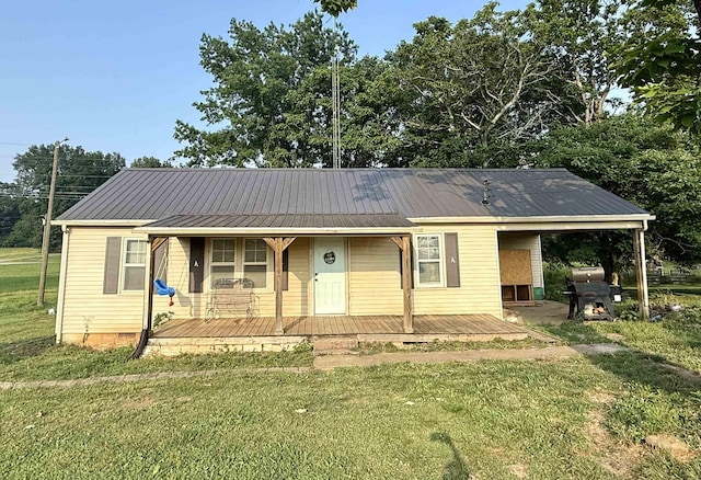 - view of front of property with a front lawn, metal roof, and covered porch