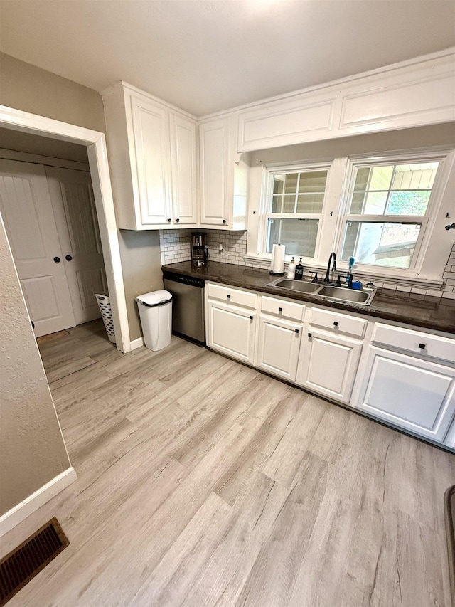  - kitchen featuring a sink, dishwasher, light wood-style flooring, decorative backsplash, and white cabinetry
